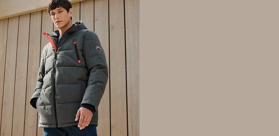 Varm, grå vinterjakke med hette kombinert med jeans.