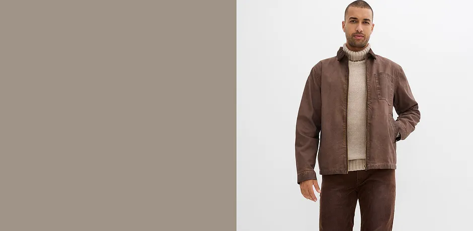 Brun skinnjakke, beige, høyhalset genser og passende bukse.