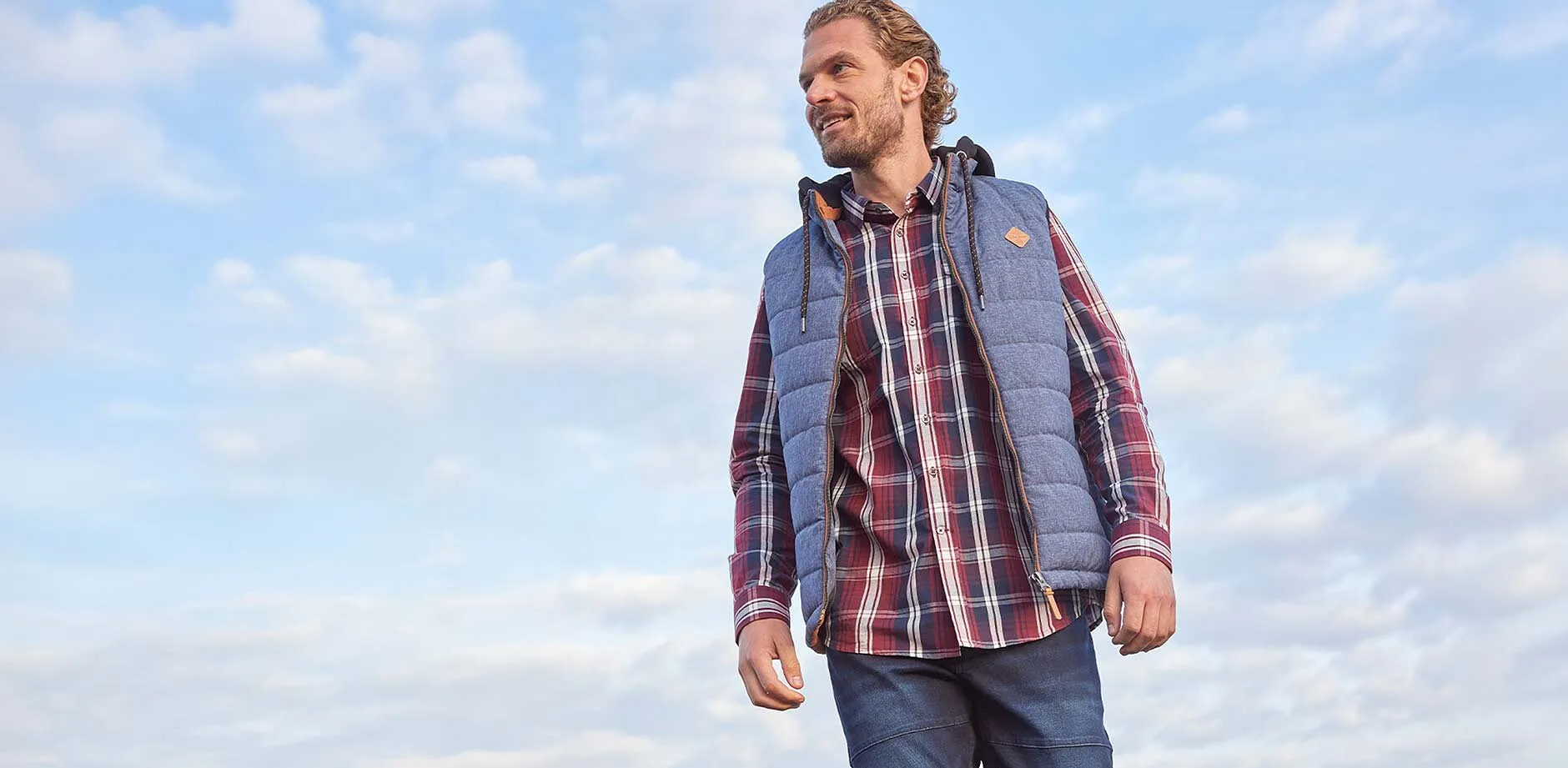 Rutete skjorte, bluejeans og grå vest.