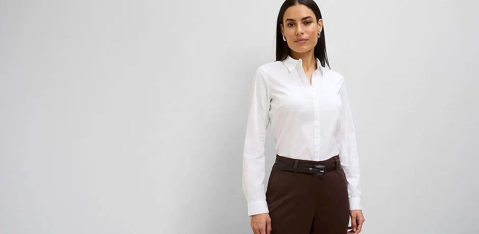 Hvit bluse kombinert med en elegant, brun bukse.
