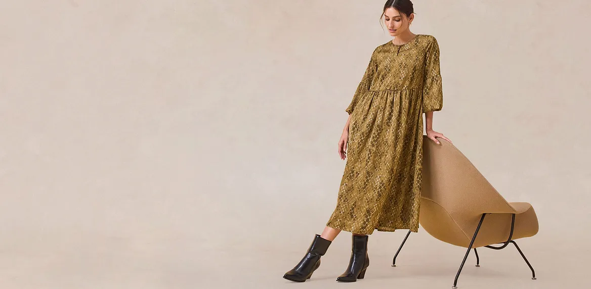 Elegant, grønn kjole med lange ermer.