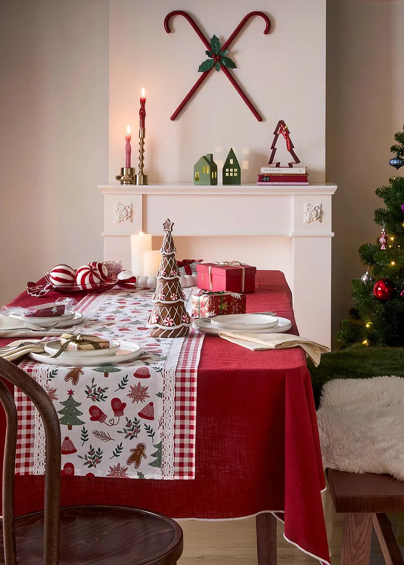 Festlig bordduk med julemønster pynter det dekkede bordet.