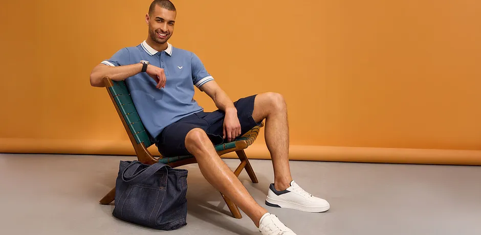 Sporty polotrøye, shorts og hvite joggesko.