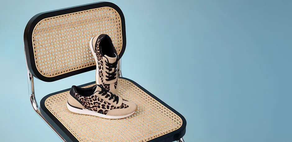 Stilige, leopardmønstrede sneakers på flettet underlag.