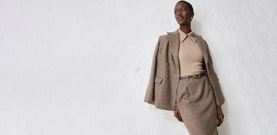 Beige blazer med passende, strikket genser og skjørt.