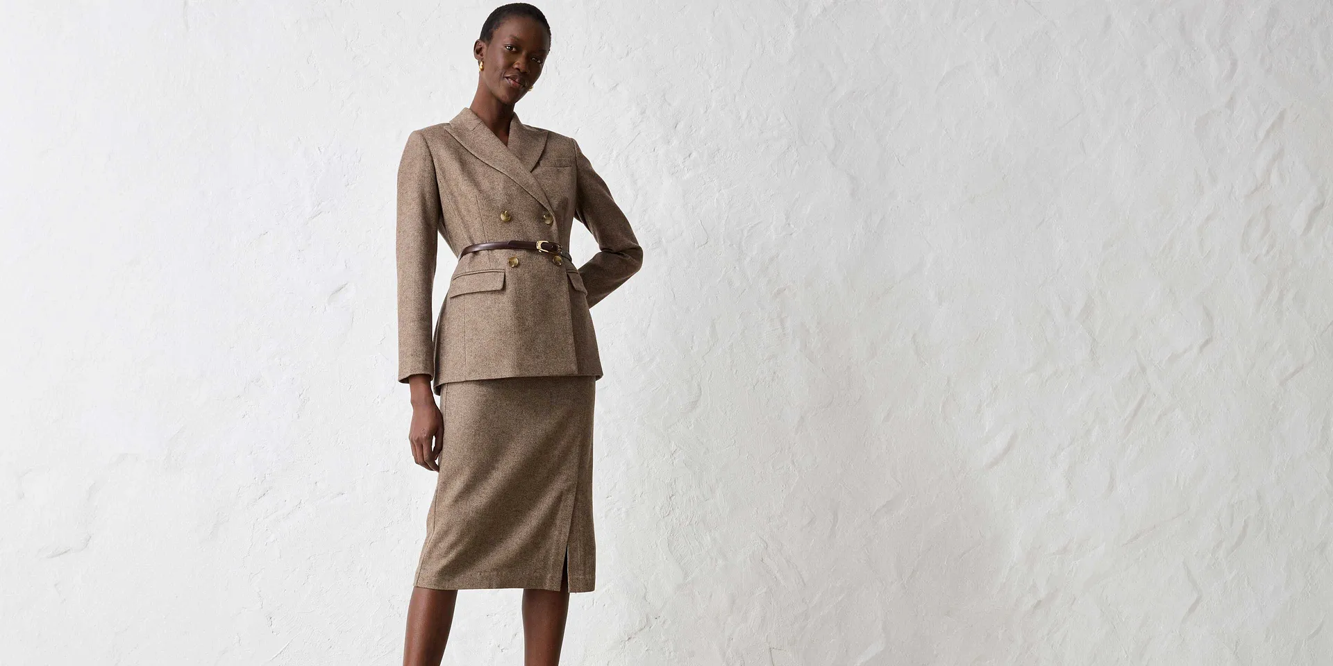 Beige blazer med belte kombinert med passende skjørt.
