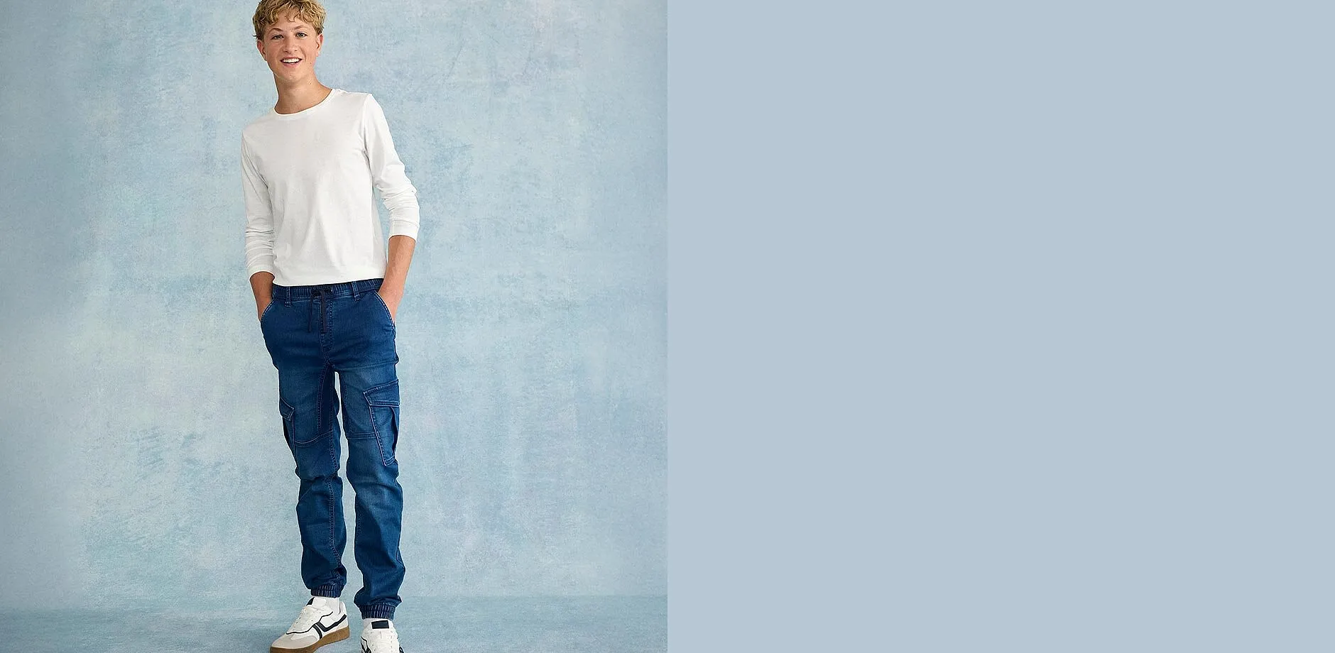 L&auml;ssiger Look: Wei&szlig;er Pullover mit blauen Jeans und wei&szlig;en Sneakers.