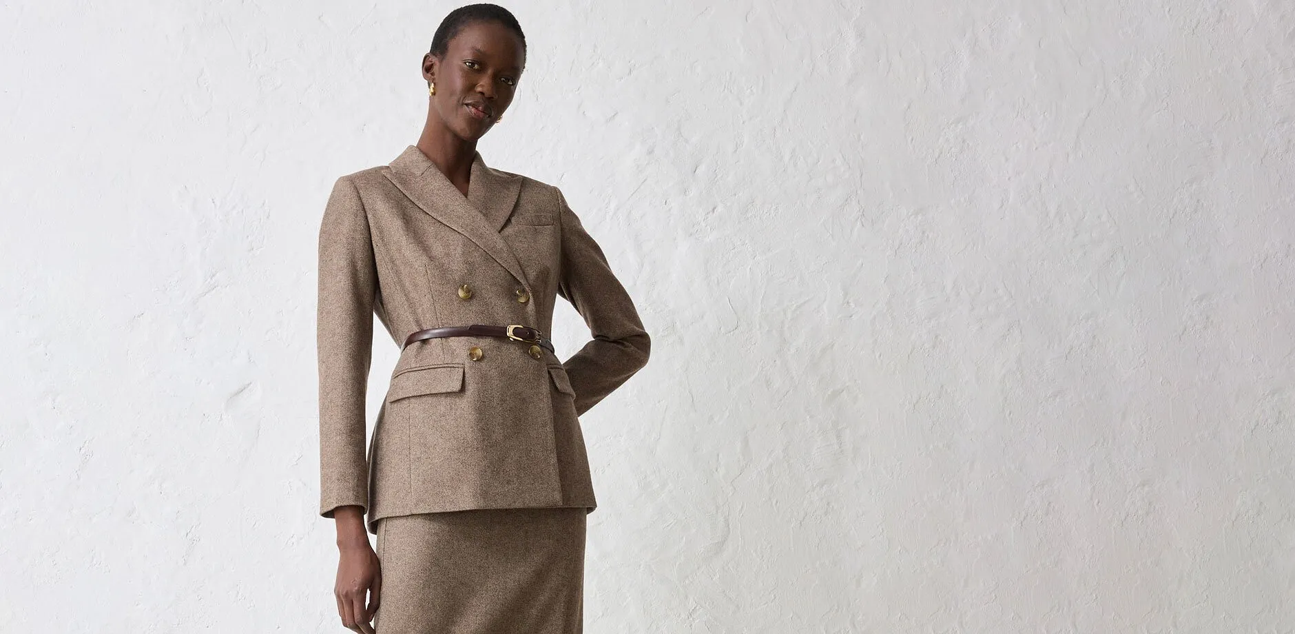 Beige blazer med belte kombinert med passende skjørt.