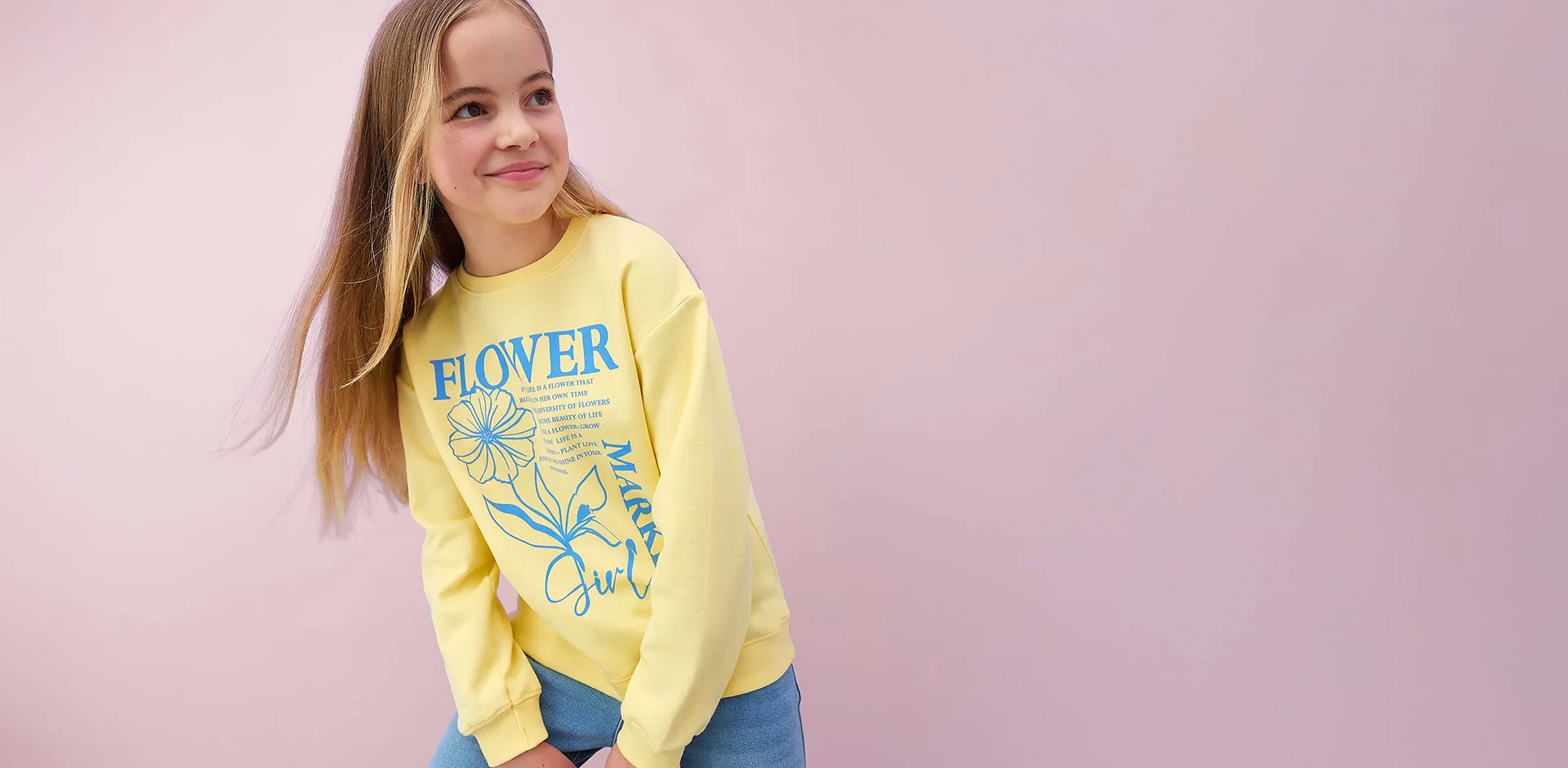 Gul, langermet topp med blomsterm&oslash;nster og tekst.