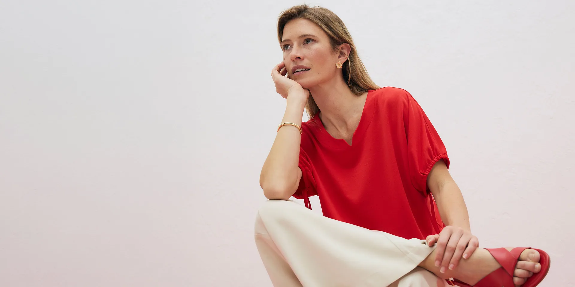 Elegant, r&oslash;d topp med V-hals kombinert med en lys bukse.