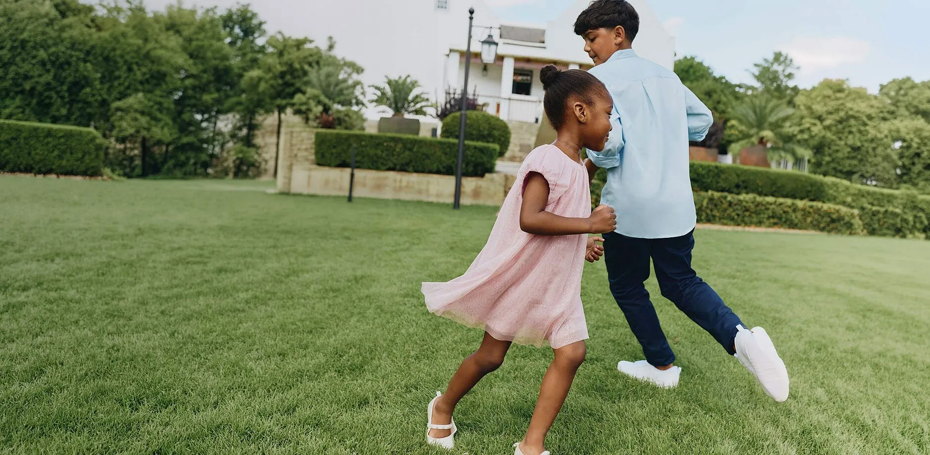 Lysebl&aring; skjorte, bl&aring; bukse, rosa kjole og hvite sko til festen.
