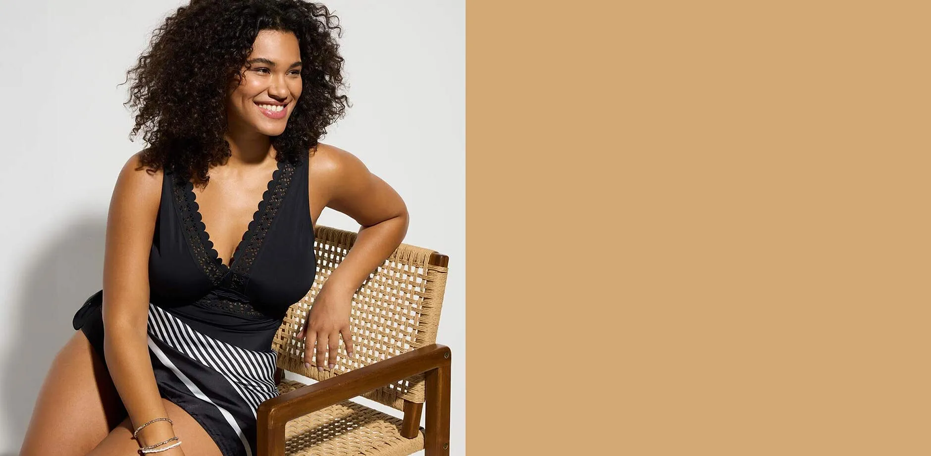 Sort badedrakt med V-hals og lasercut-innfellinger.