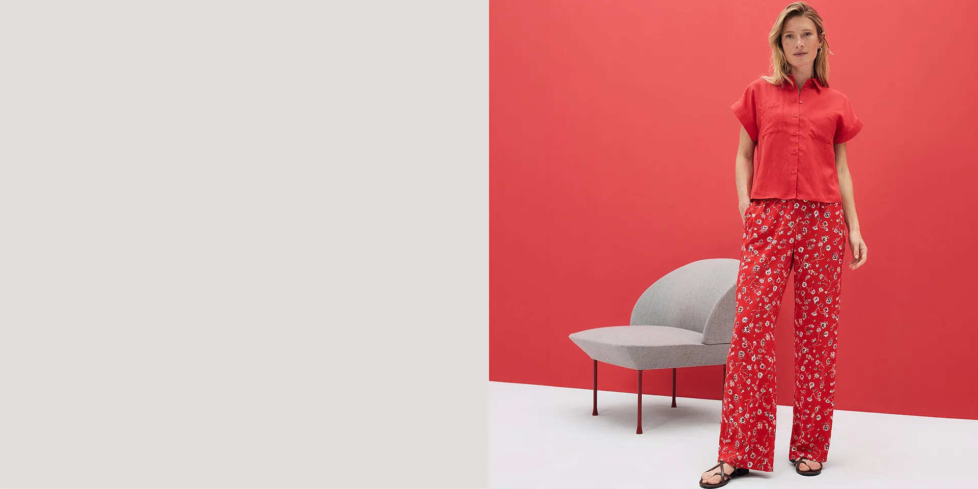 R&oslash;d, kortermet skjorte og blomstrete bukse med pent fall. Sommerantrekk foran lysende r&oslash;d bakgrunn.