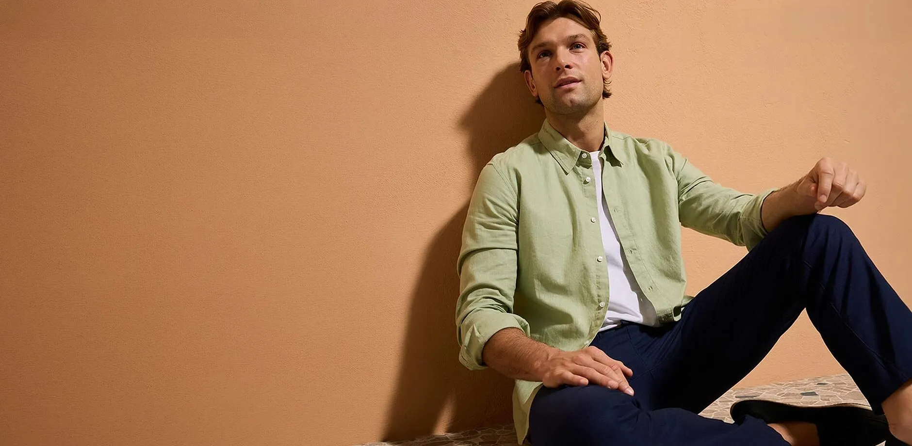 Pastellgr&oslash;nn skjorte, m&oslash;rkebl&aring; bukse og uformelle sko.