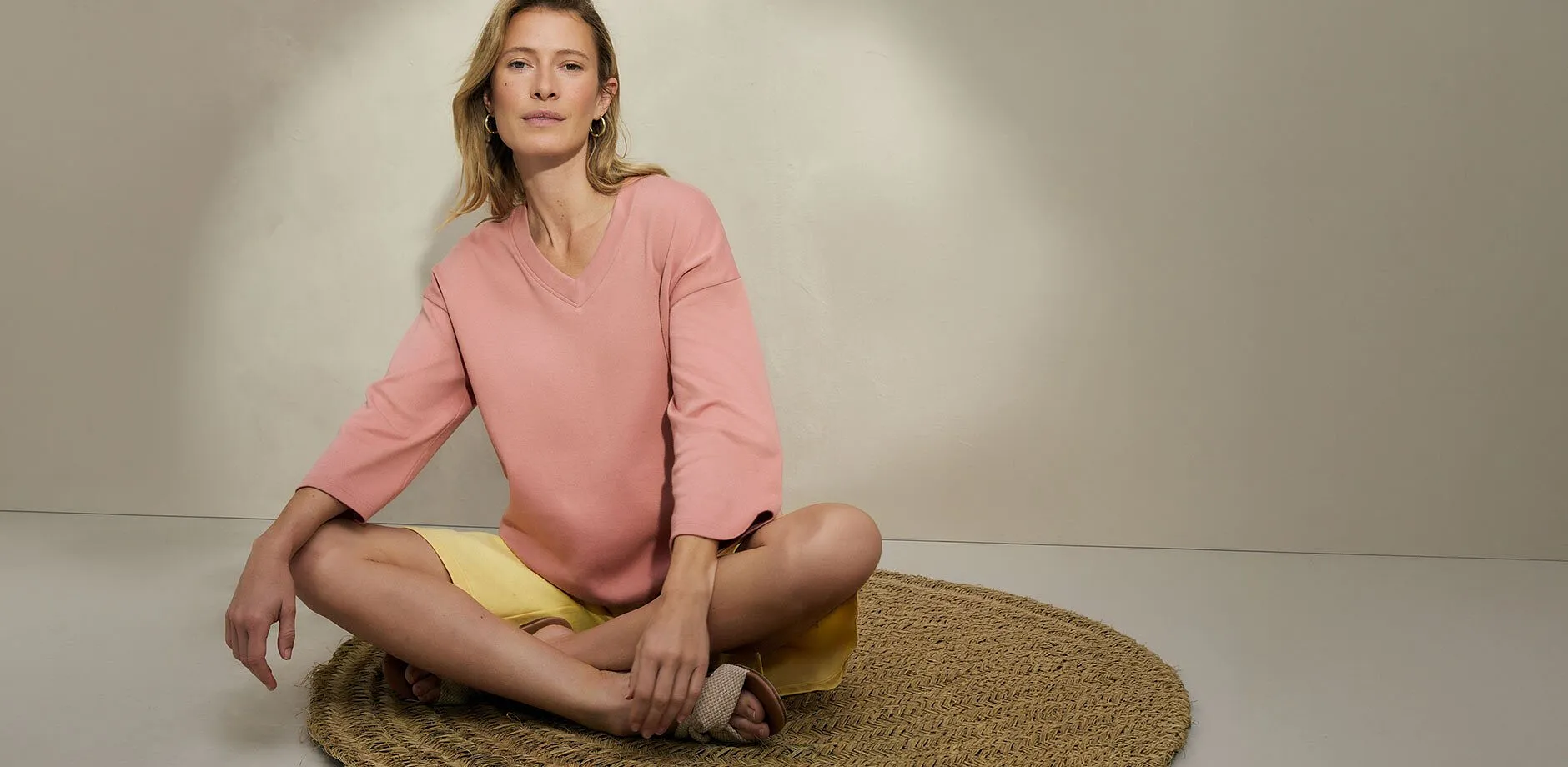 Kvinne i rosa bluse og gul shorts.