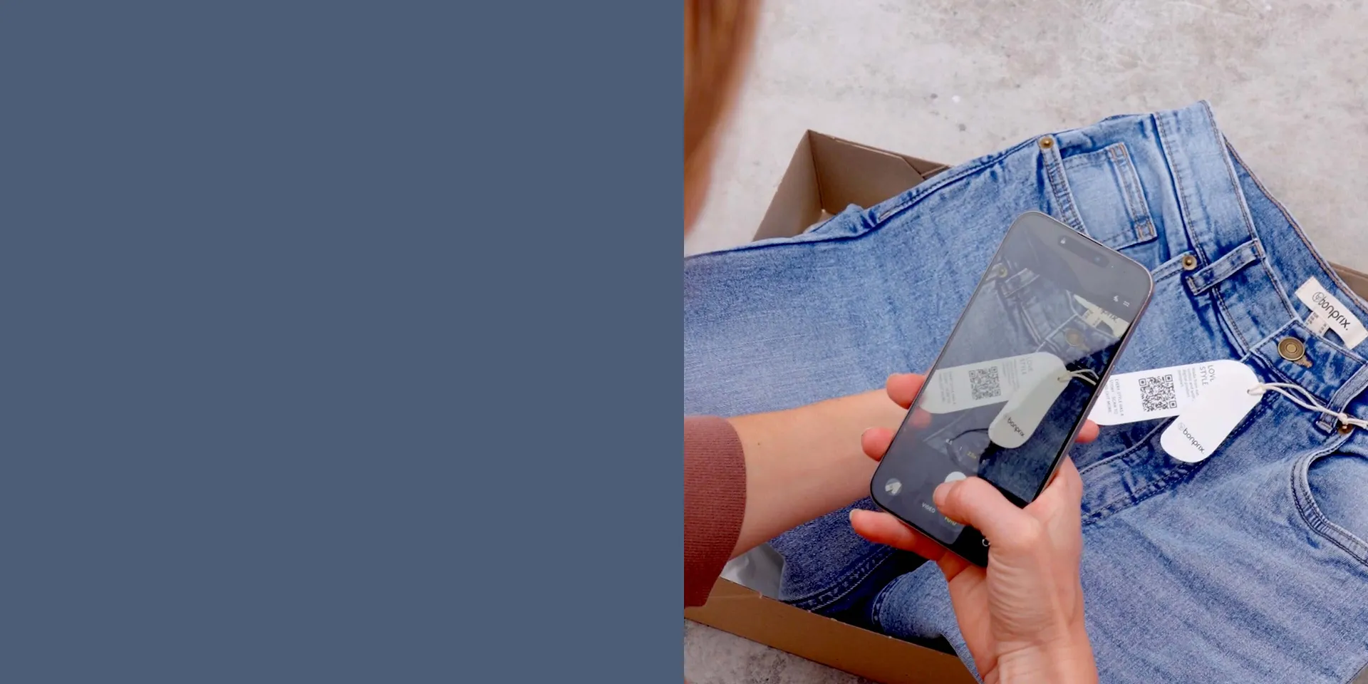 Bluejeans p&aring; gr&aring; bakgrunn. Hender holder smarttelefonen over kl&aelig;rne.