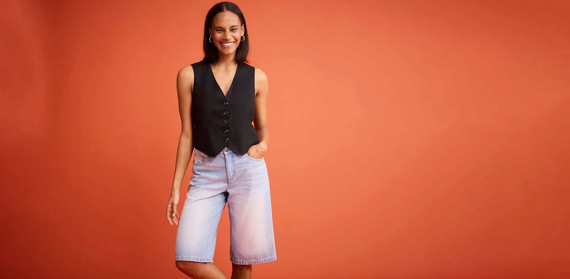 Sort vest med knapper kombinert med lysebl&aring; denimshorts.