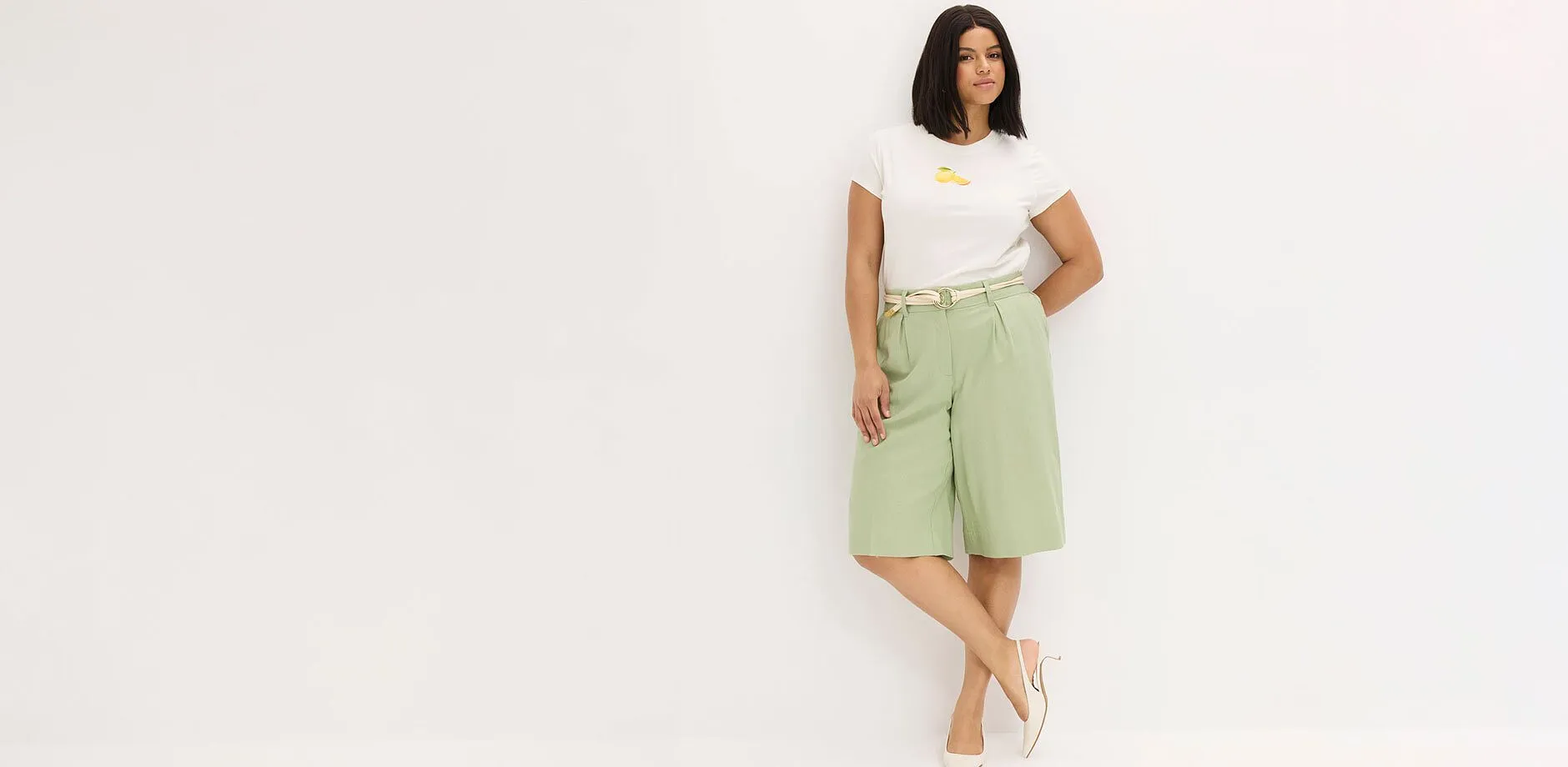 Hvit T-skjorte, mintgr&oslash;nn bermudashorts og beige sandaler.
