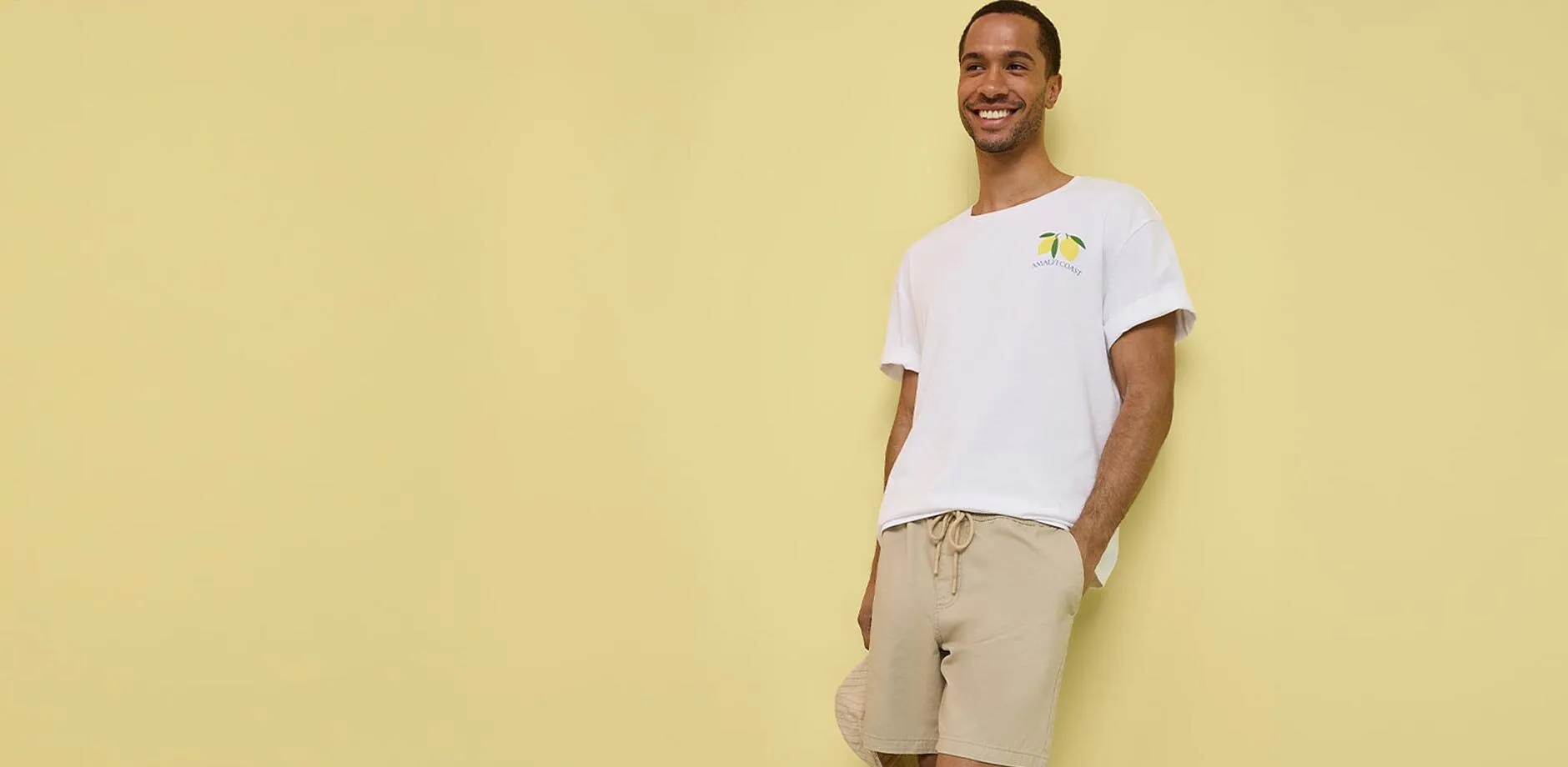 Avslappet antrekk med hvit T-skjorte, beige shorts og hvite sneakers.