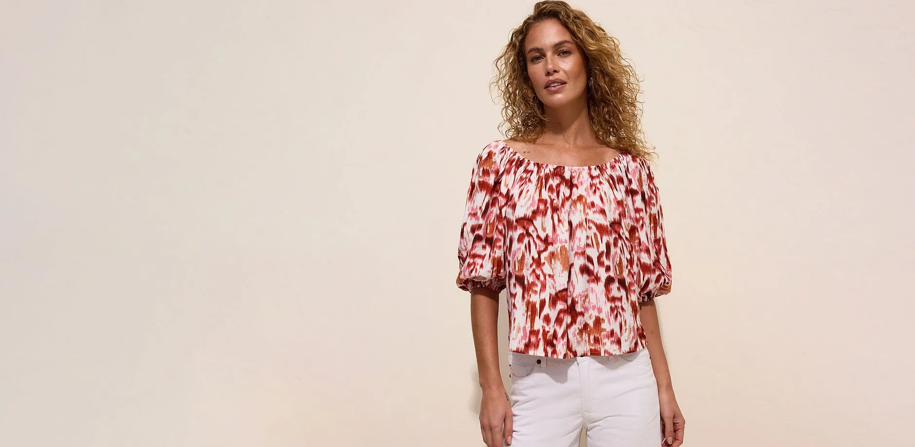 Off shoulder-bluse med livlig m&oslash;nster og behagelige, hvite jeans.