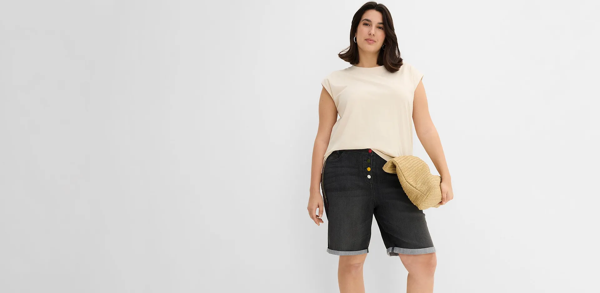 Beige topp og m&oslash;rk bermudashorts i denim med oppbrett.