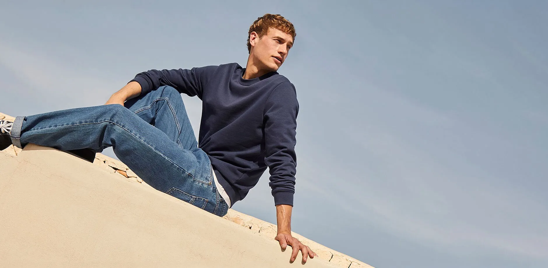 Stilren, bl&aring; sweatshirt, klassiske jeans og sneakers.