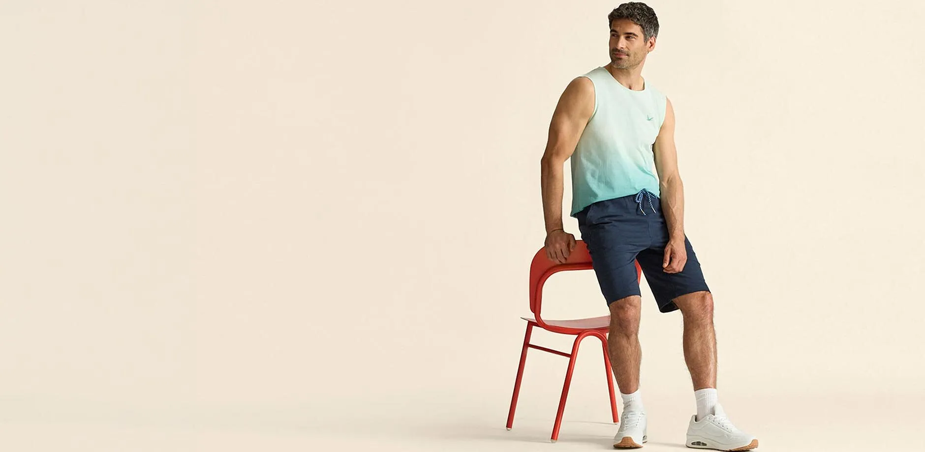 Trendy singlet med fargegradering kombinert med bl&aring; shorts og hvite sneakers.