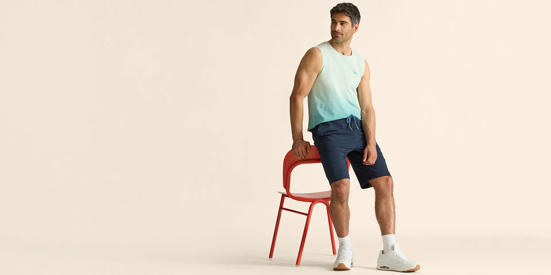 Trendy singlet med fargegradering kombinert med bl&aring; shorts og hvite sneakers.