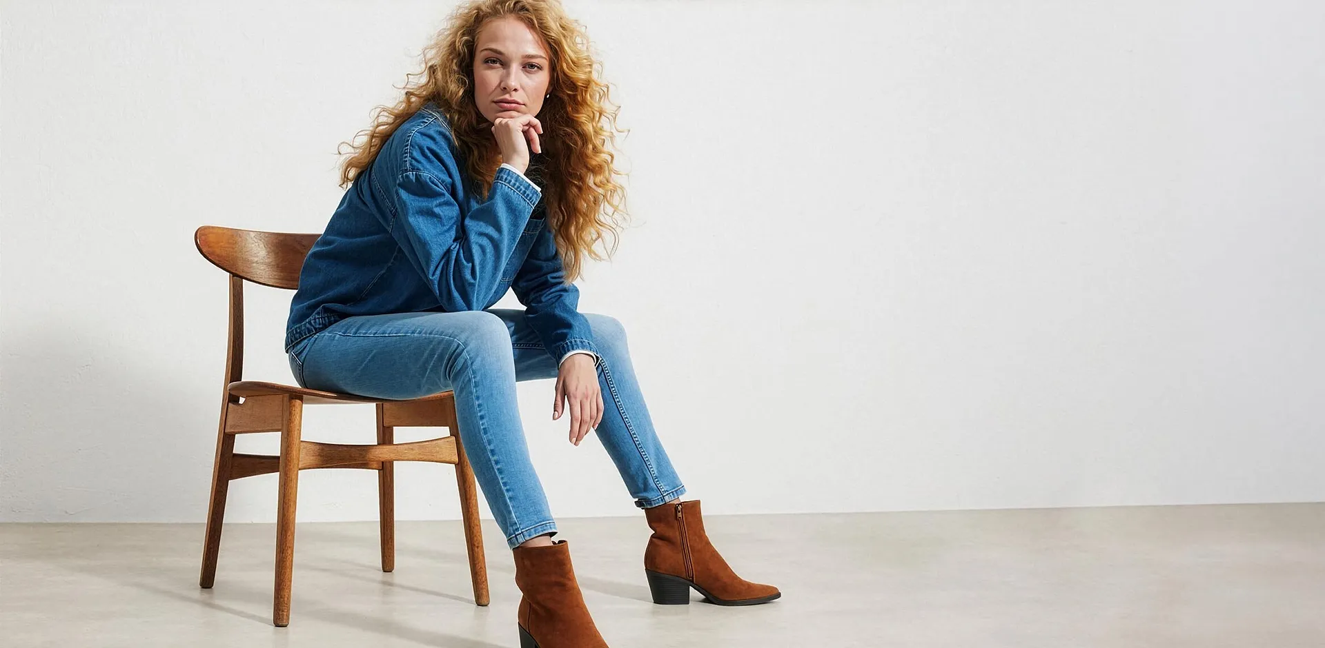 Person i bl&aring; denimjakke, jeans og moteriktige, brune ankelst&oslash;vletter.