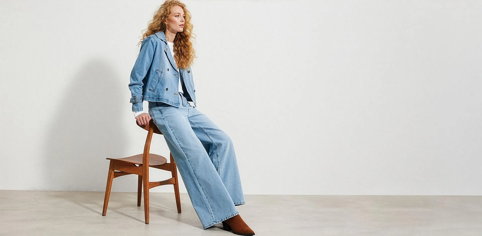 Kort, lysebl&aring; denimjakke, vid bukse og hvit topp.