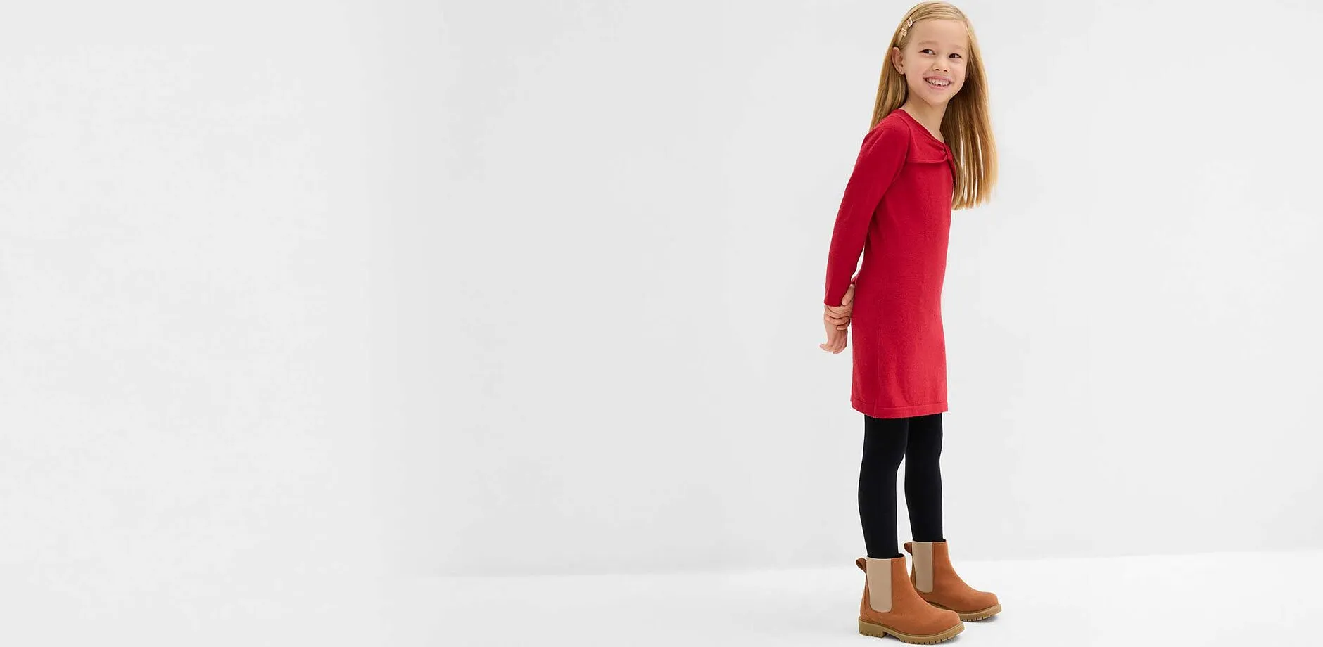 Lite barn i r&oslash;d strikkekjole.