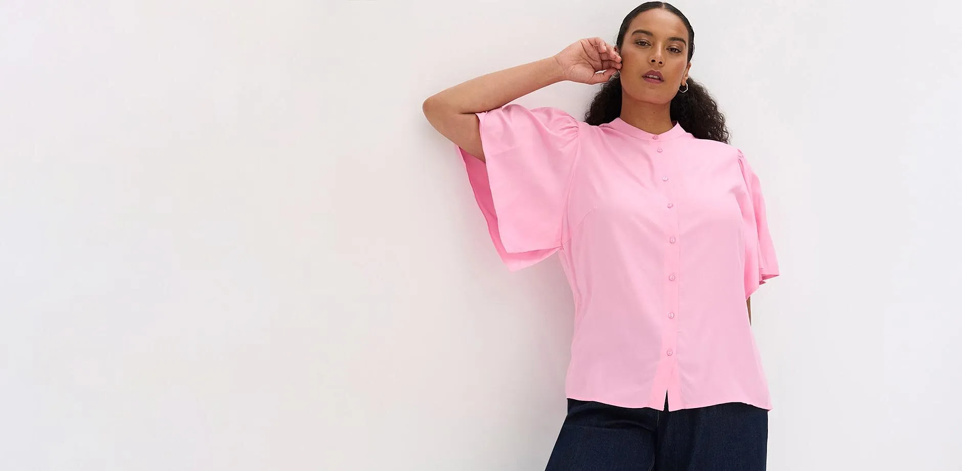 Rosa bluse med vide ermer, st&aring;krage og knappestolpe.