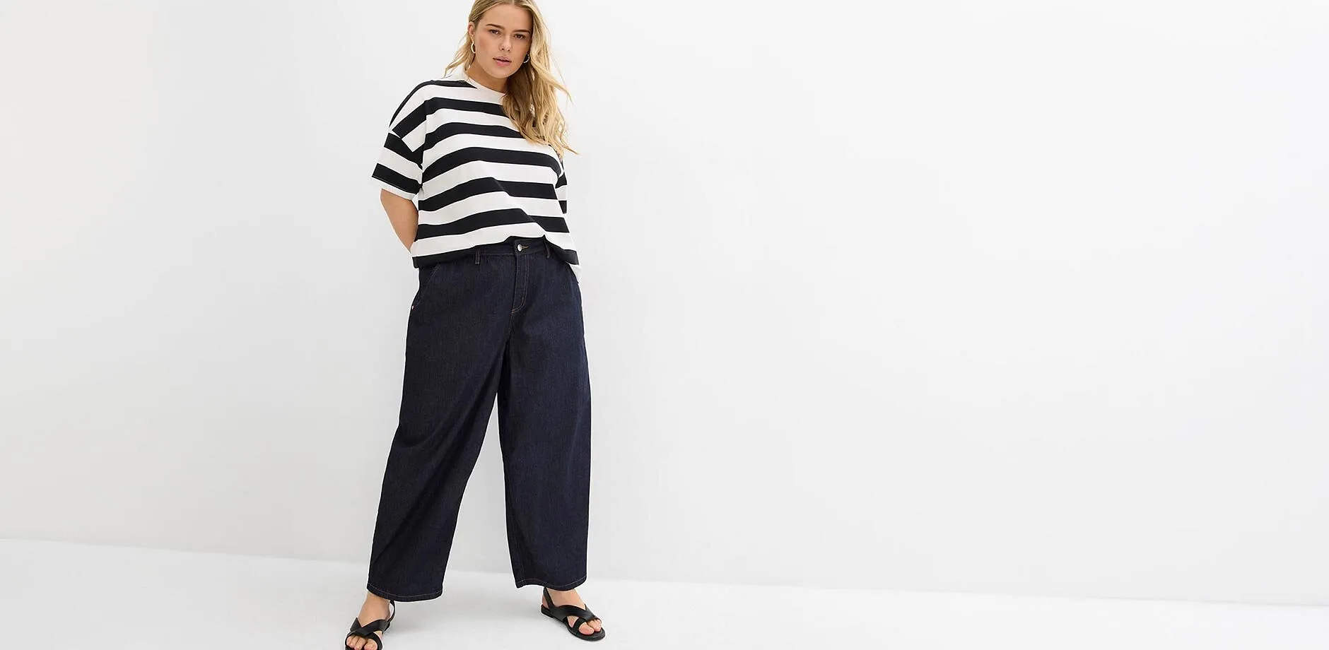 Stripete topp, vide, m&oslash;rkebl&aring; jeans og sorte sandaler.