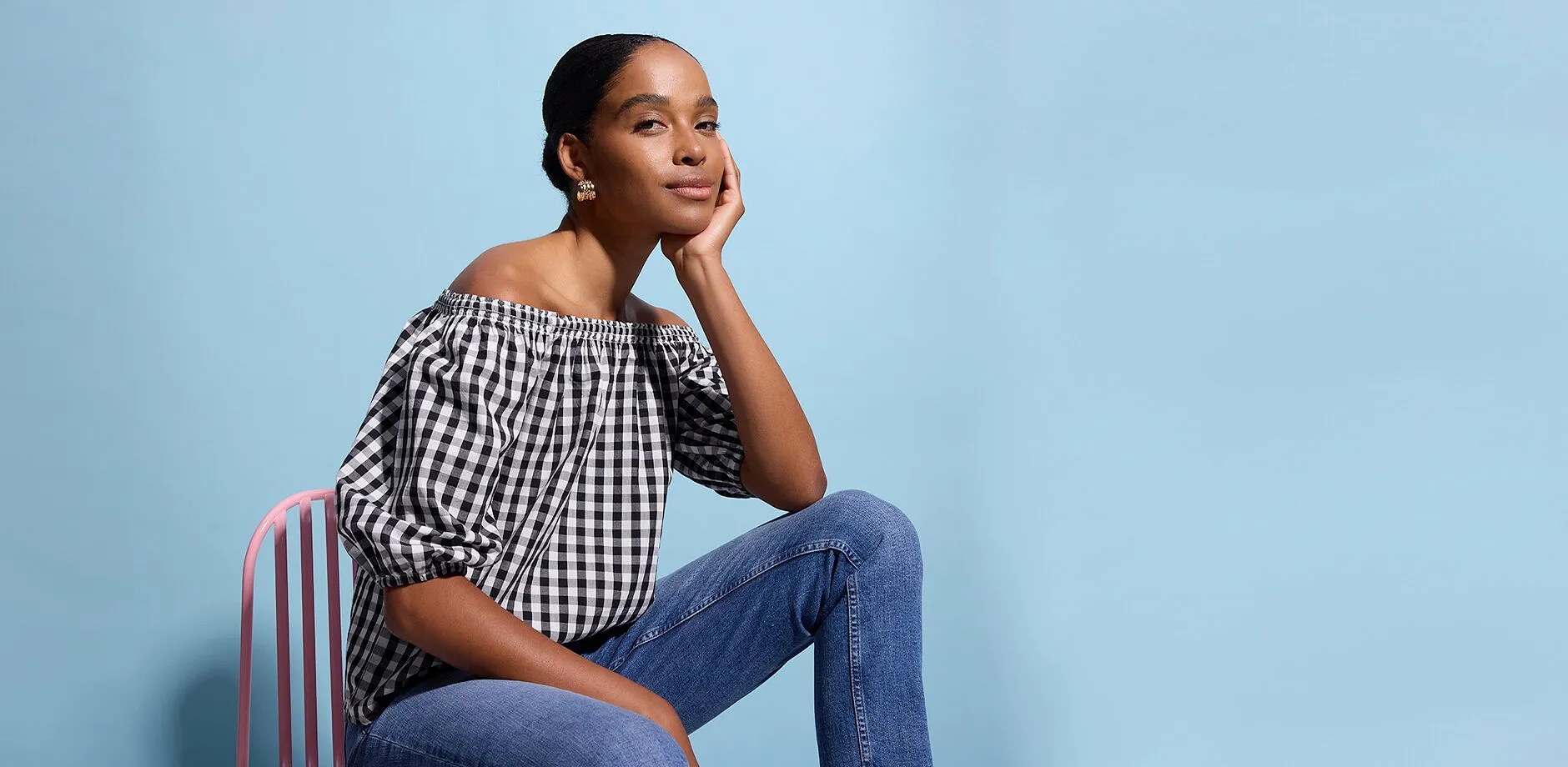 Person i off-shoulder-bluse og avslappede jeans.