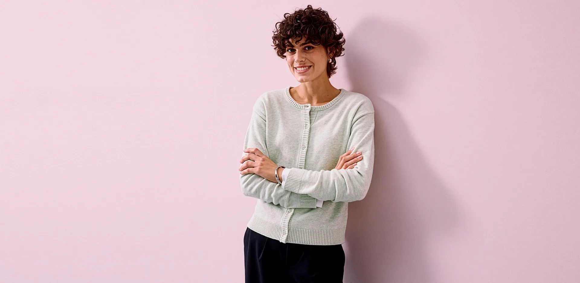 Lysegr&oslash;nn cardigan kombinert med elegant, sort bukse.