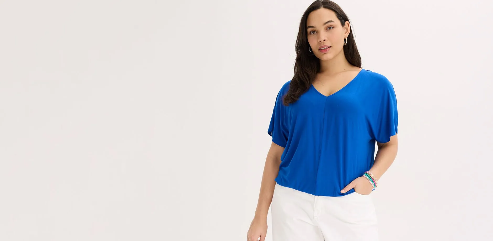 Bl&aring;, oversized topp med V-hals og hvit bukse.
