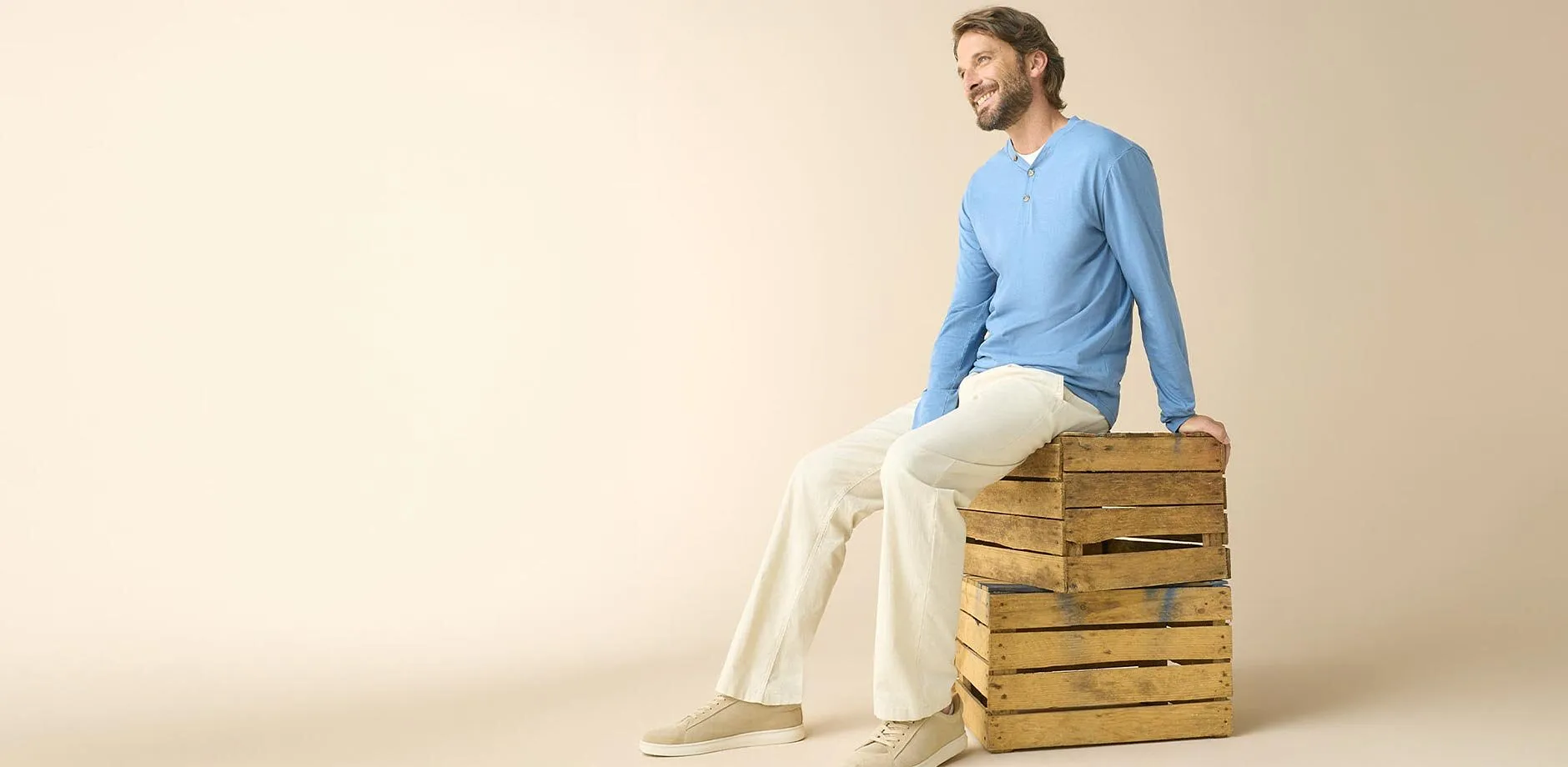 Person kledd i lysebl&aring;, tynn genser, lys bukse og beige sneakers.