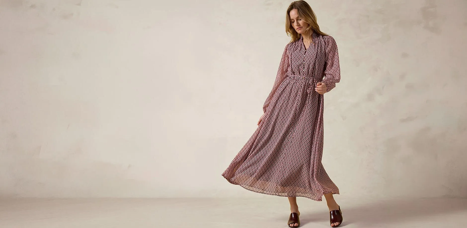 M&oslash;nstret maxikjole med lange ermer og elegante slip-ins.