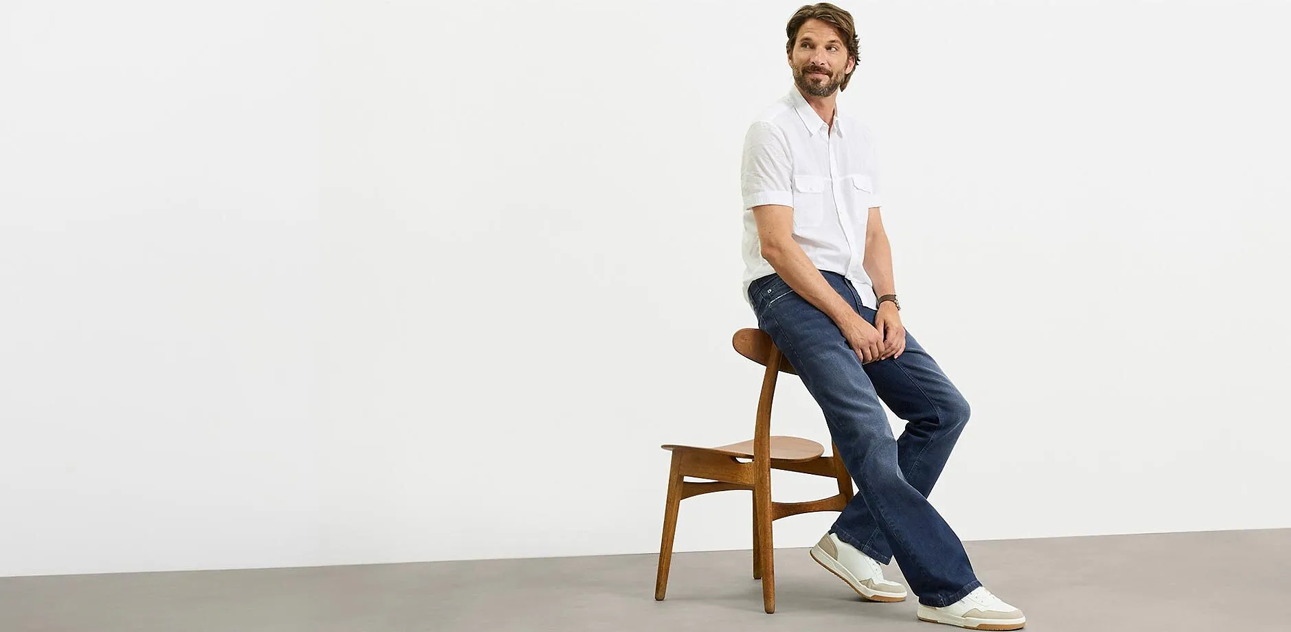 Hvit, kortermet skjorte, m&oslash;rke jeans og hvite sneakers s&oslash;rger for en avslappet stil.
