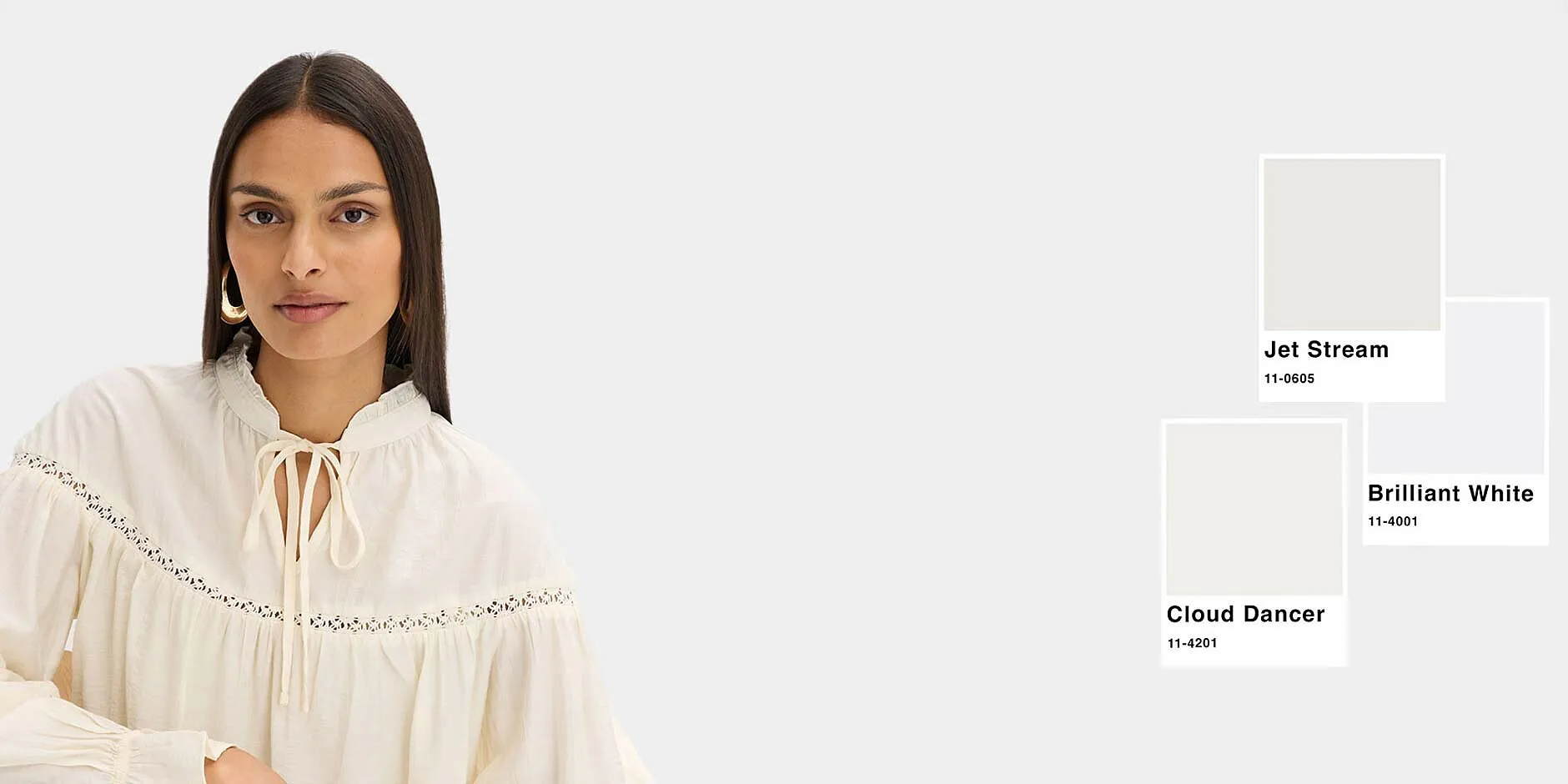 Elegant, kremhvit bluse med broderi, perfekt avstemt med de hvite fargetonene.