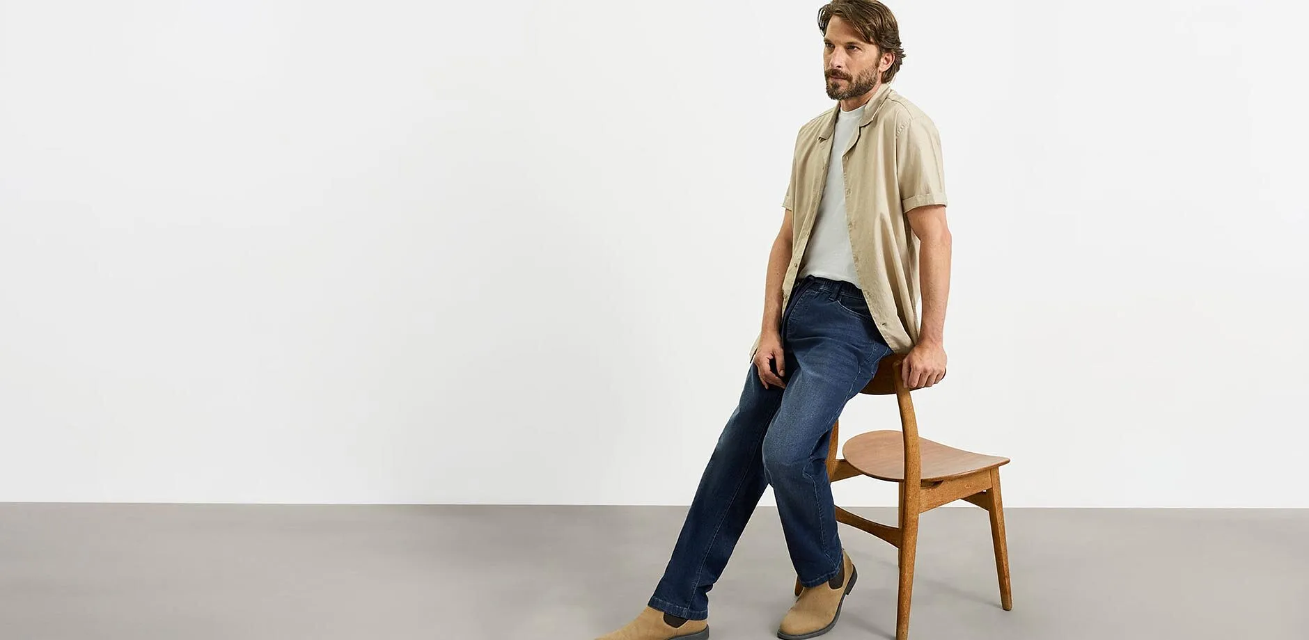Beige skjorte, gr&aring; T-skjorte, bluejeans og brune sko i semsket skinn for en stilig, avslappet look.