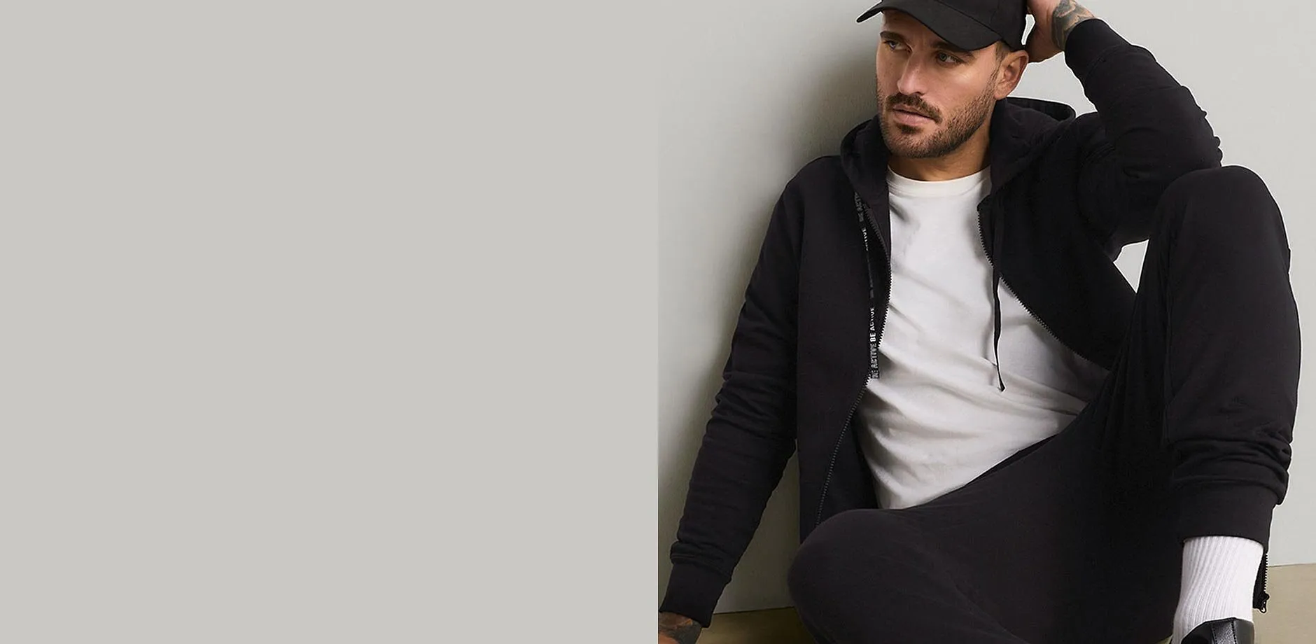 Sort caps, hettejakke, hvit T-skjorte og sort joggebukse for en avslappet stil.