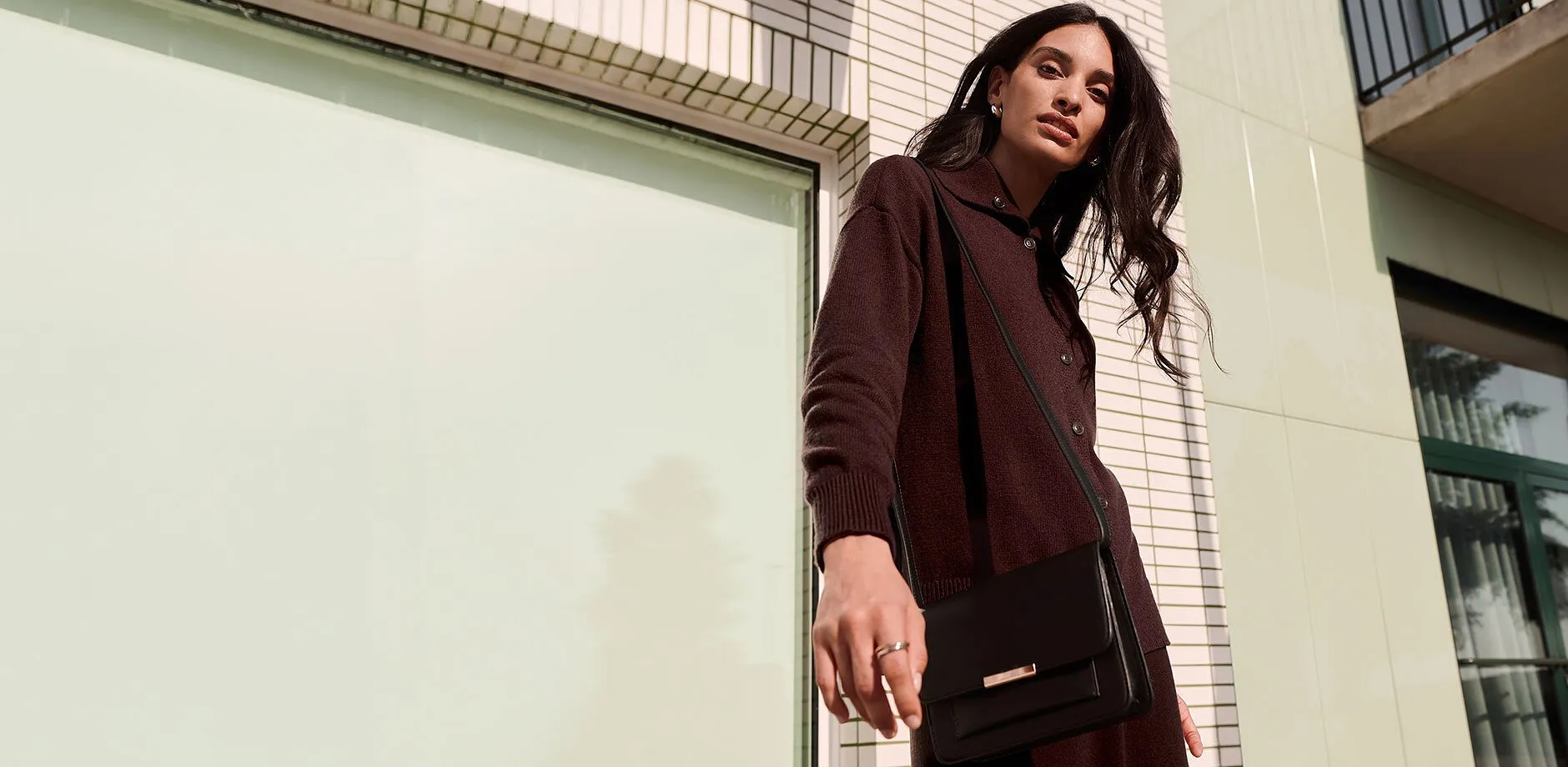 M&oslash;rk cardigan, elegant, sort veske og fine smykker for en stilfull look.