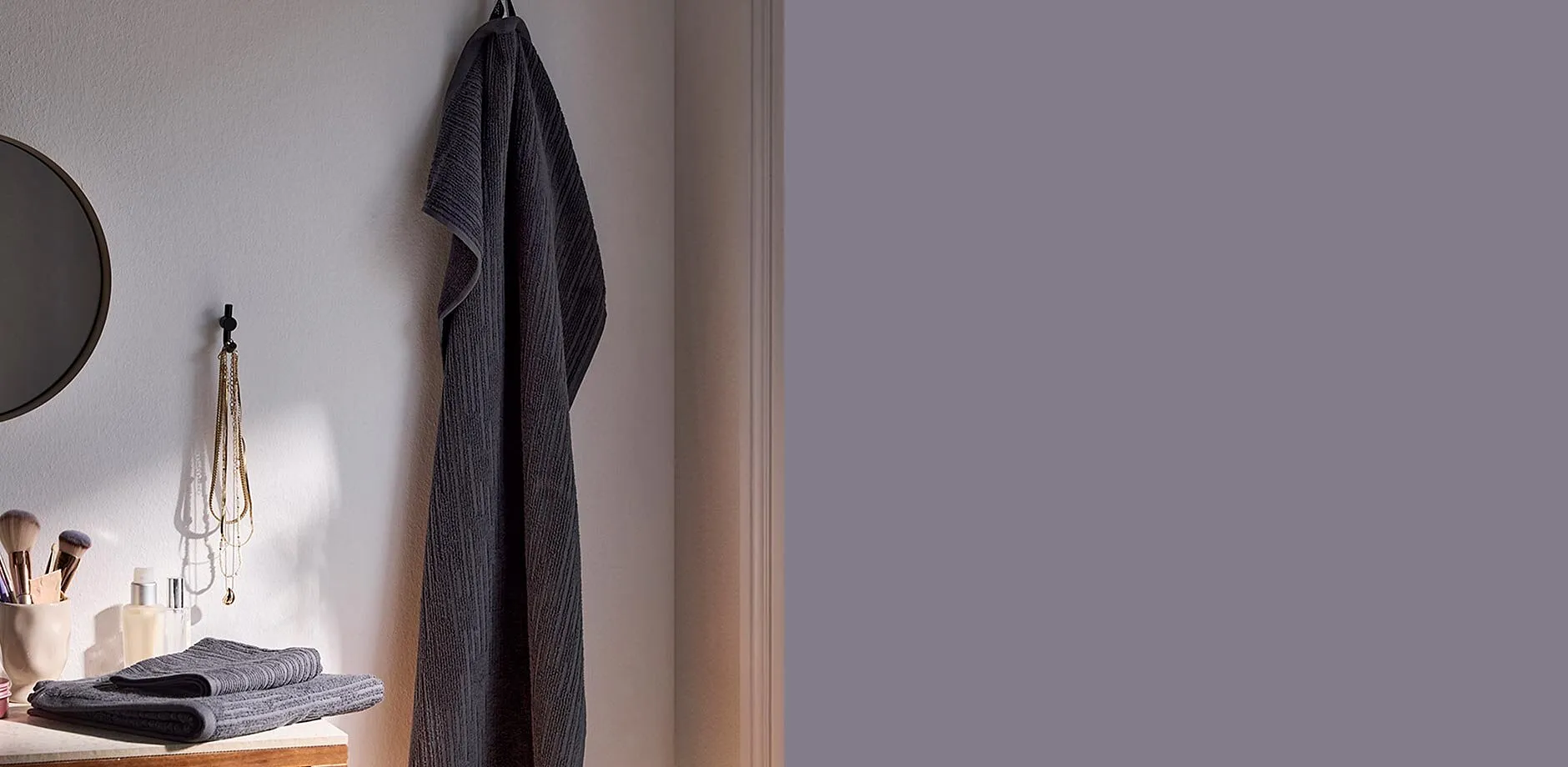 Et stort, gr&aring;tt h&aring;ndkle henger p&aring; badet.