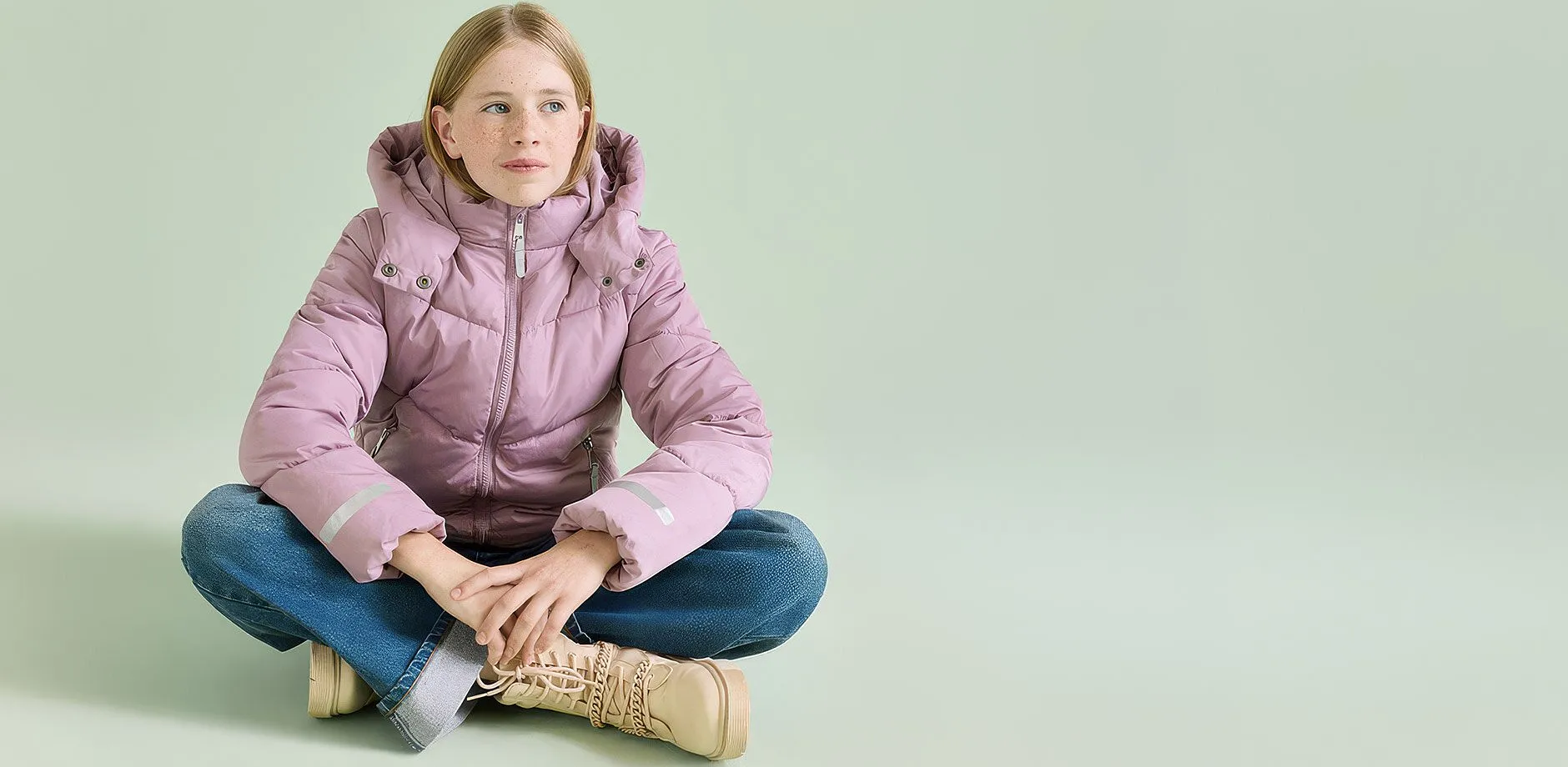 Varmt antrekk best&aring;ende av rosa boblejakke, bl&aring; jeans og beige boots.