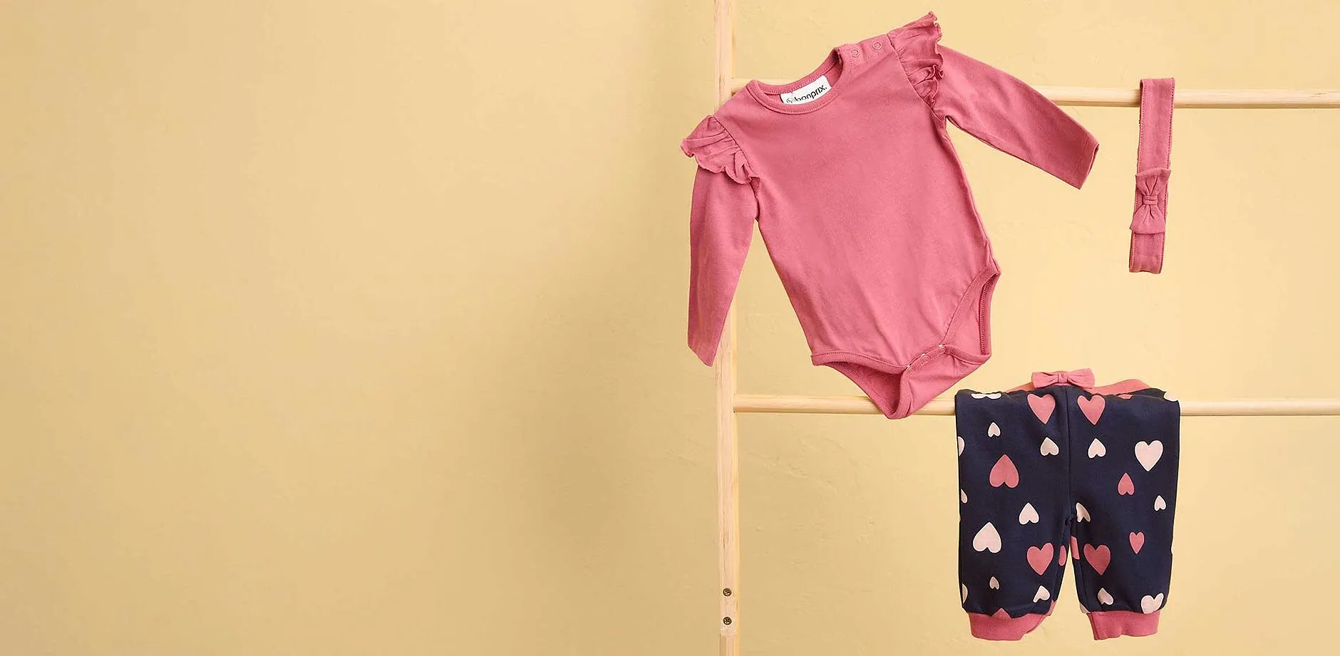 S&oslash;tt sett til baby: Rosa body og m&oslash;rkebl&aring; bukse med hjertem&oslash;nster.