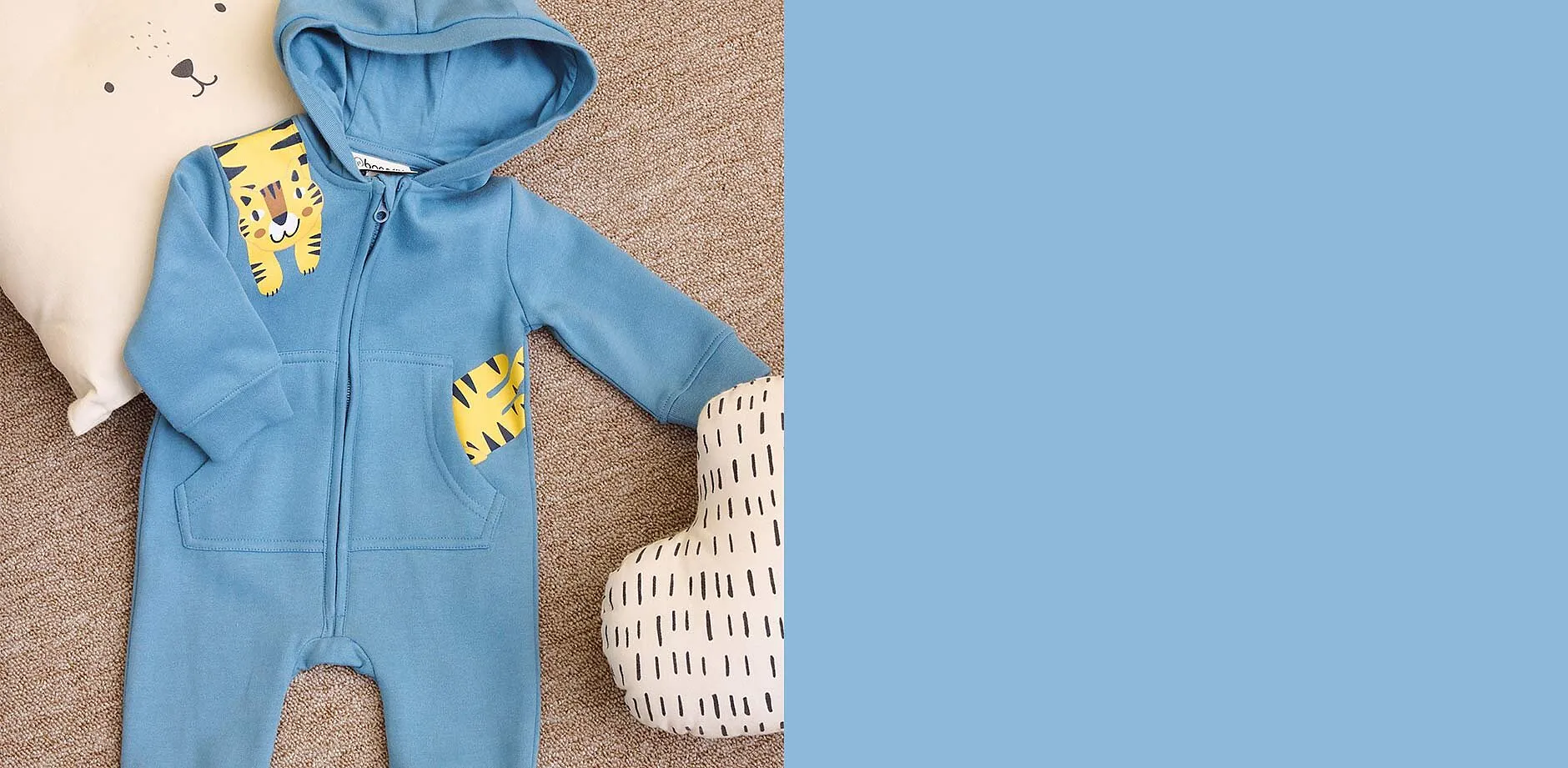 Bl&aring; overall med hette og s&oslash;tt tigertrykk.