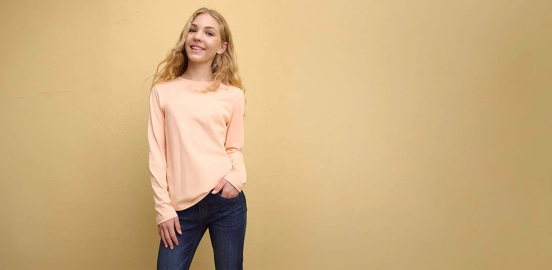 Bl&aring;, langermet topp med Helly Kitty-trykk, bluejeans og rosa caps.