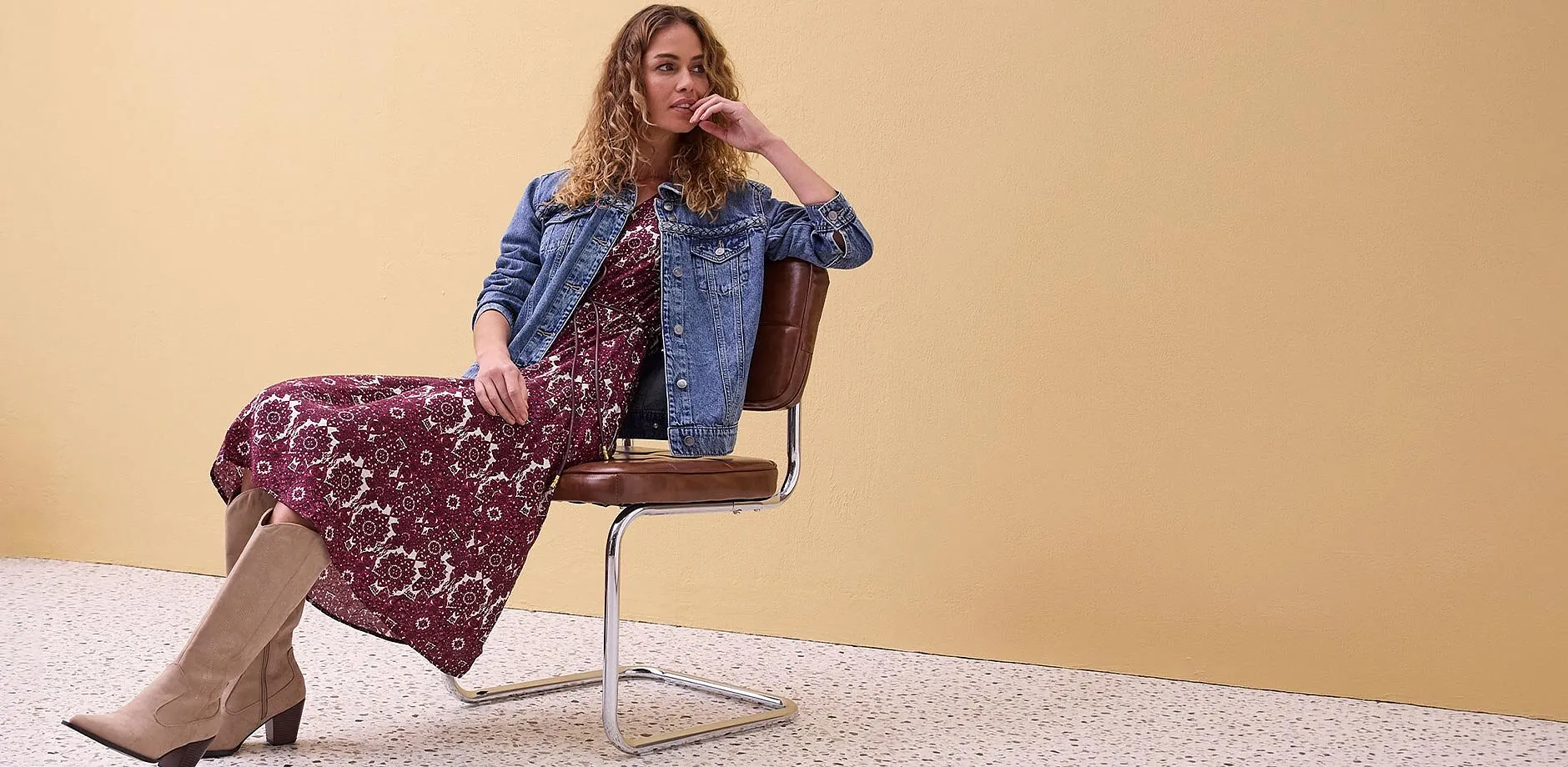 Denimjakke over blomstrete kjole kombinert med beige st&oslash;vletter.