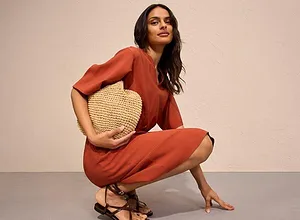 Rustfarget jumpsuit med korte ermer samt stråveske og fine sandaler.